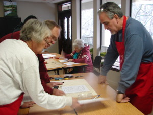 "Instructors Elisabeth and Pete Ave-Lallimont working with student, Randy Presley on his Stain Glass project, while BettyeAnn Cooper works in the background"