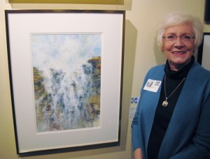 Diana Foote stands next to her award-winning watercolor “Seaside Waterfall” at the Mid-Southern Watercolorists Exhibition in Little Rock. (photo by Mike Foote)